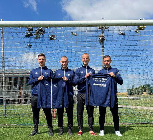 Vier Mitglieder des SV Blau-Weiss 55 Schortewitz e.V. präsentieren stolz ihre neuen Trainingsanzüge.