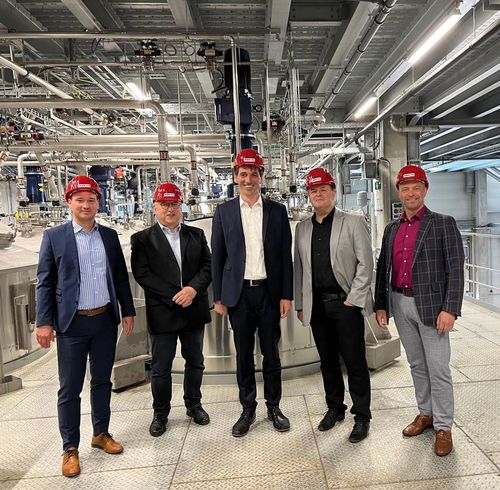 Gruppenfoto von fünf Personen mit rotem Schutzhelm in den Werkshallen der IPT Pergande GmbH.